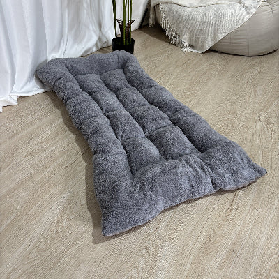 Matelas pour chien​ gris vide sur planchers de bois du salon