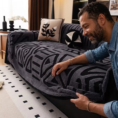 Protection canapé chien gris foncé sur canapé noir avec homme montrant le tissu